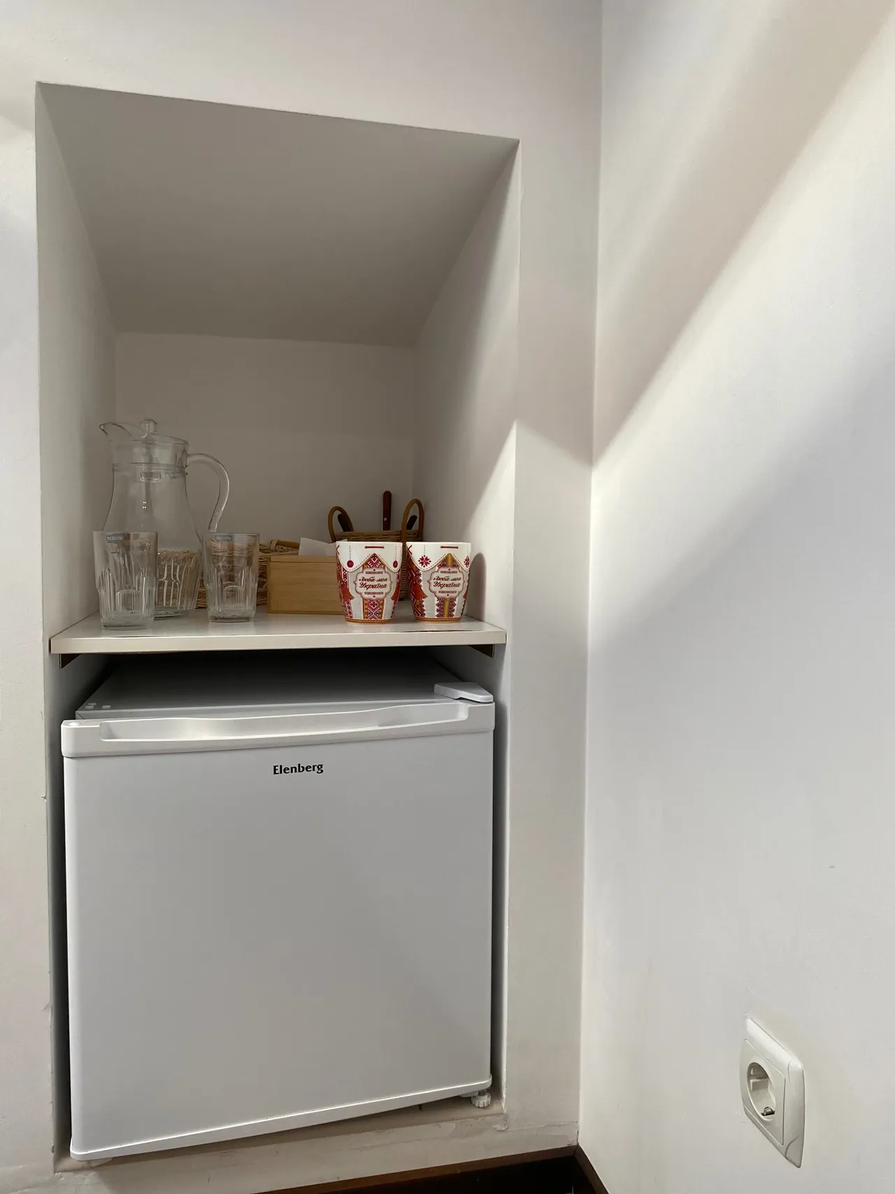 Fridge with mugs and glasses in the attic room
