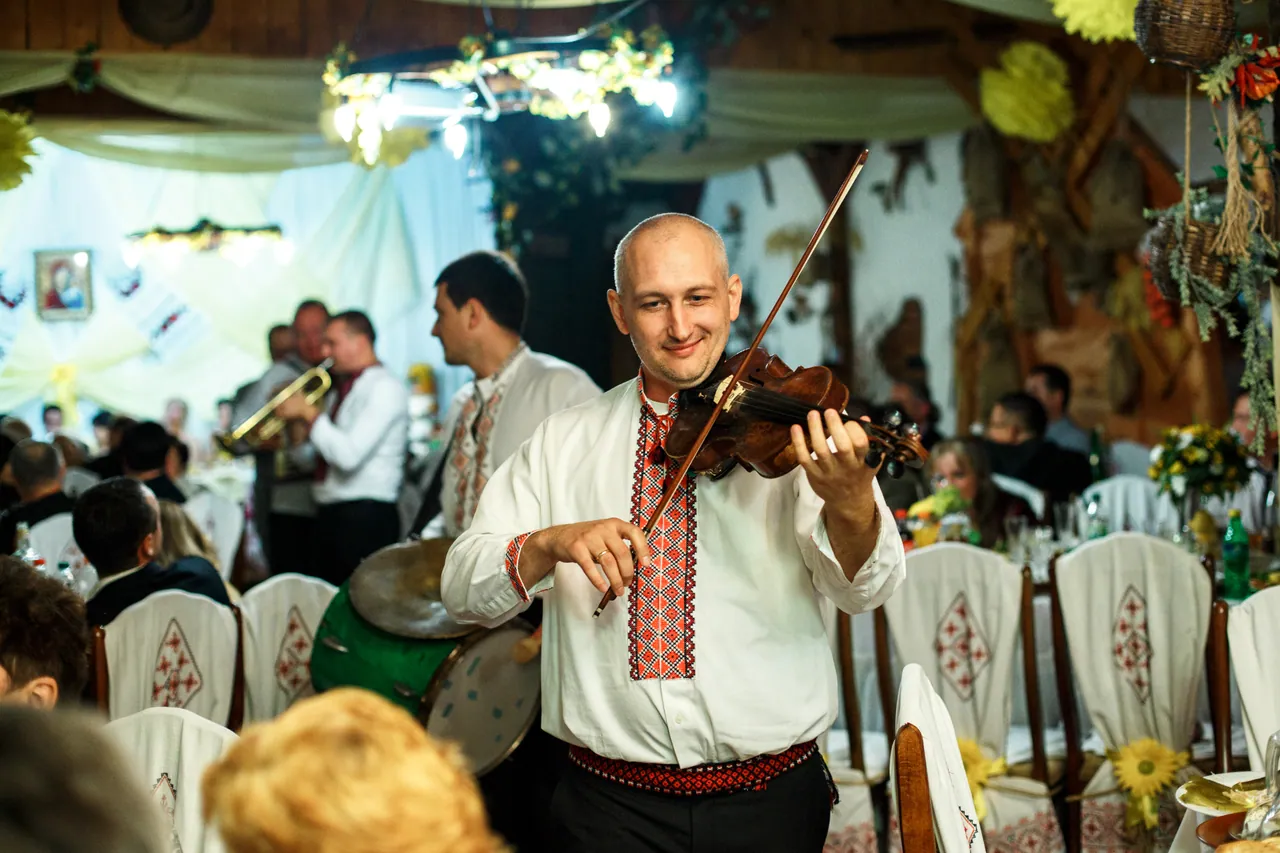 A musician in an embroidered shirt plays the violin during a celebration at Stizhok