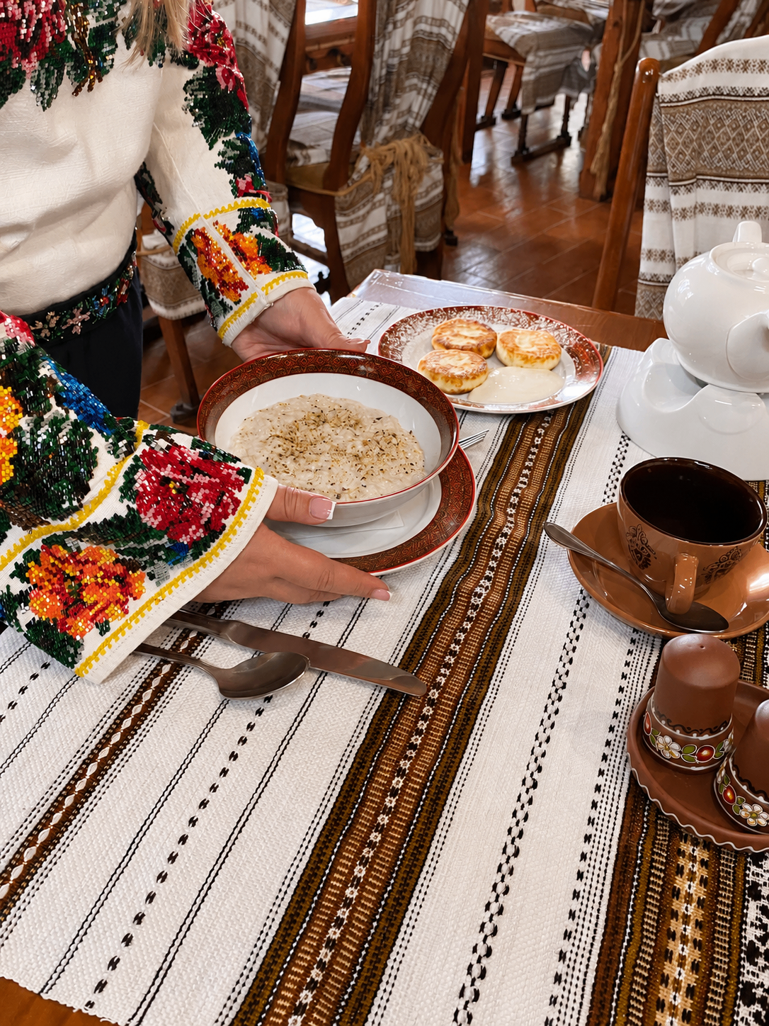 Подача сніданку в «Стіжку»: руки зі стравами на сервірованому столі