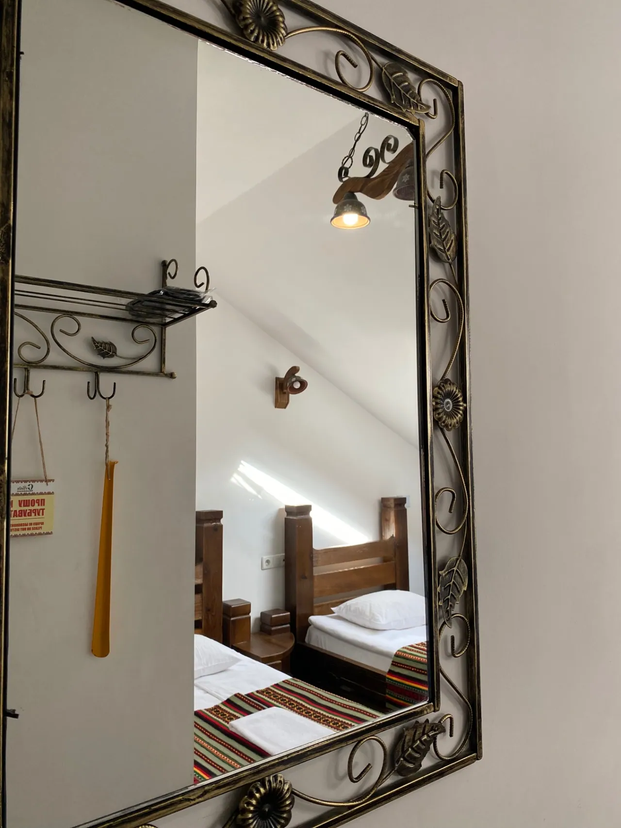 Wrought-iron mirror frame in the attic room with two single beds